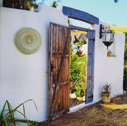 an open door in a wall with a hat at Pura Vida Tofo Beach Houses in Praia do Tofo