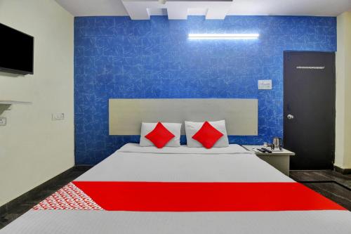 a bedroom with a large bed with red pillows at Hotel O Lavish Stay in Hyderabad