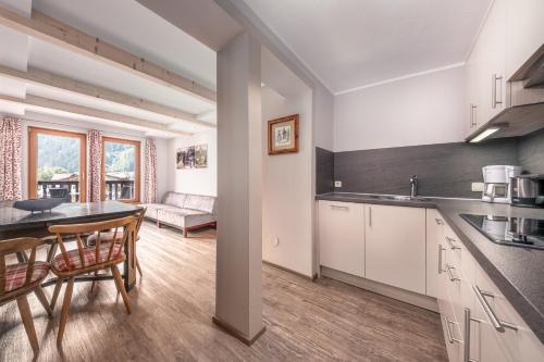 a kitchen and living room with a table and chairs at das Huber in Mayrhofen