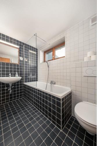 a bathroom with a tub and a sink and a toilet at das Huber in Mayrhofen