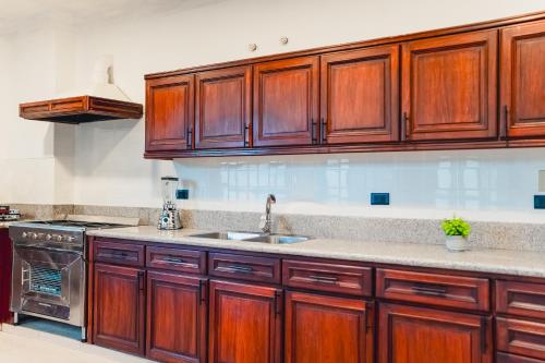 a kitchen with wooden cabinets and a sink at Casa 11-24 by Casa Bolivar in Cuenca