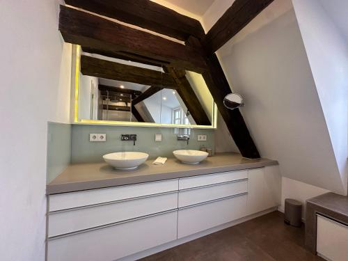 a bathroom with two sinks and a mirror at DOM LIVING - LuxusHaus in Fulda
