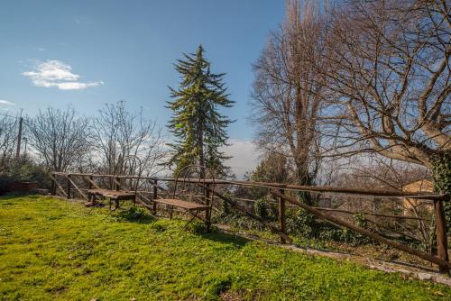 two benches sitting on a grassy hill next to a fence at Da Bacchetta in Assisi