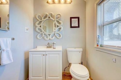a bathroom with a toilet and a sink and a mirror at Charming Laurel Home with Gazebo and Fireplace! in Delmar
