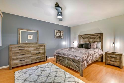 a bedroom with a bed and a dresser and a mirror at 2 Mi to Six Flags Lake George Home with Large Patio in Queensbury