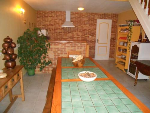 a living room with a table and a brick wall at La Grange in Nohant-Vic