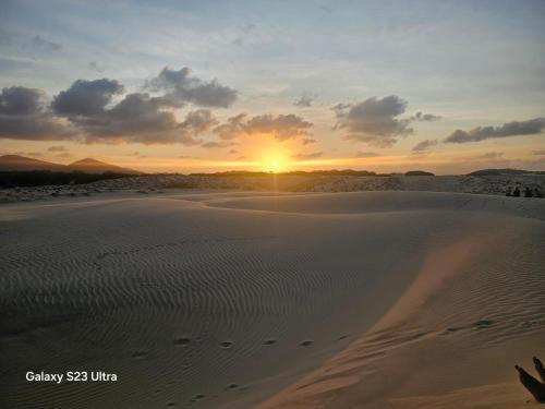 a sunset over the sand dunes in the desert at FRENTE MAR - Cumbuco - Eco Paradise in Cumbuco