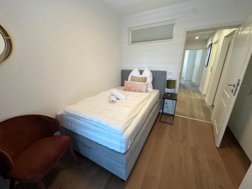 a small bedroom with a bed and a chair at DOM LIVING - LuxusHaus in Fulda