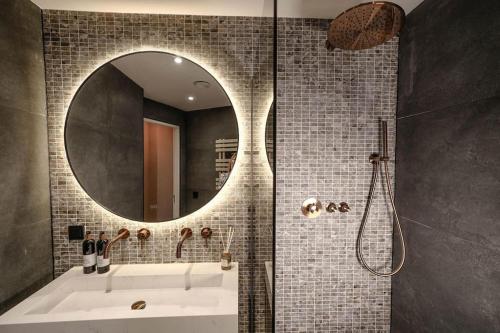 y baño con bañera y espejo redondo. en Haya Beachhouse - King, en Scheveningen