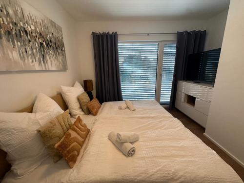 a bedroom with a large white bed with towels on it at DOM LIVING - LuxusHaus in Fulda