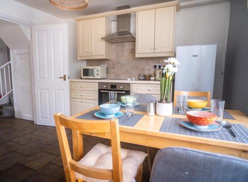 a kitchen with a table with bowls and plates on it at Coastal Terrace Retreat- Allocated Parking, 2 Bedrooms in Portsmouth