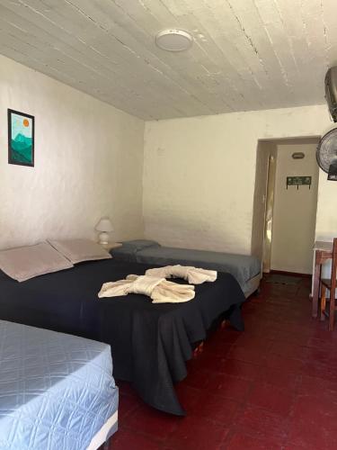 a room with two beds and a table and chairs at Sauce Viejo in Mina Clavero