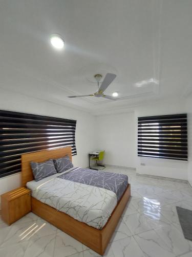 a bedroom with a bed and two windows at Jesskev guest place and event centre in Awuku