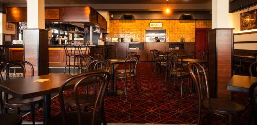 a restaurant with tables and chairs and a bar at Bat and Ball Hostel in Sydney