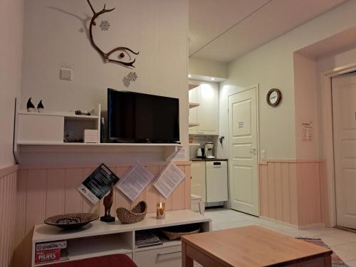 a living room with a tv and a table at RöhköStar 107 in Äkäslompolo