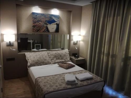 a bedroom with a bed with two towels on it at Hotel Iz in Izmir