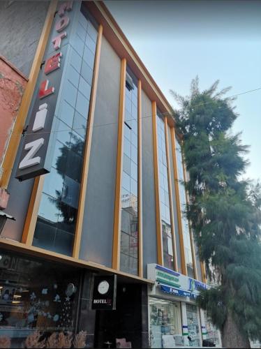 a building with a palm tree in front of it at Hotel Iz in Izmir