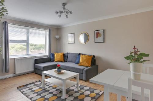 a living room with a couch and a table at Homely Apartment in Harlow in Great Parndon