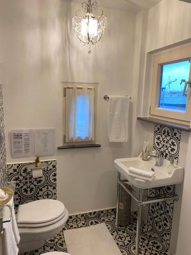 a bathroom with a sink and a toilet and a chandelier at La Baia di Napoli in Capri