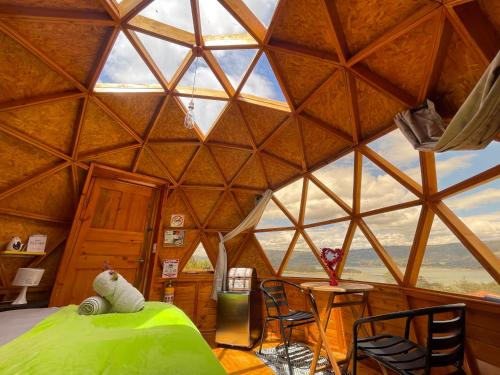 a room with a bed and chairs in a igloo at Glamping Brillo de Luna in Guatavita