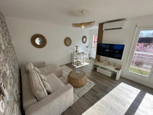 a living room with a couch and a flat screen tv at MarbleMood Spa in Obernai