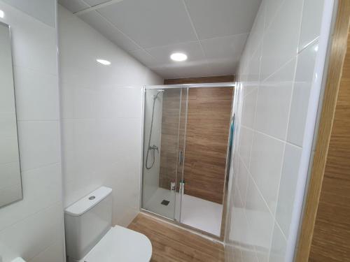 a bathroom with a toilet and a glass shower at Casa Lom in Alcora