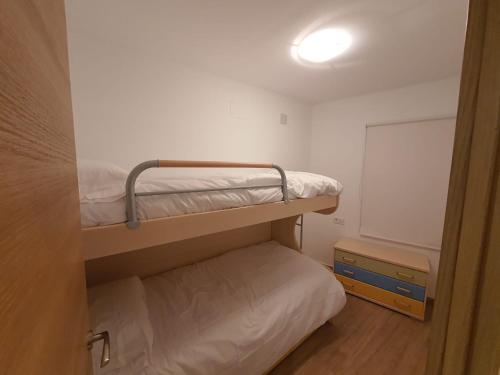 a small room with two bunk beds and a light at Casa Lom in Alcora