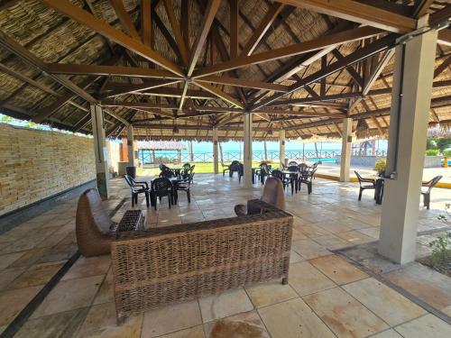 a patio with tables and chairs in a building at FRENTE MAR - Cumbuco - Eco Paradise in Cumbuco