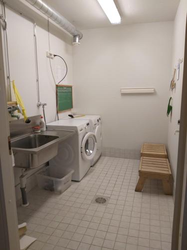 a bathroom with a washing machine and a sink at RöhköStar 108 in Äkäslompolo