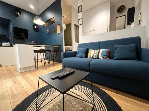 un salon avec un canapé bleu et une table dans l'établissement BeauConcept, à Nantes
