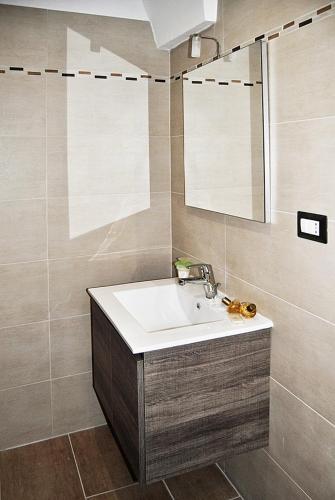 a bathroom with a sink and a mirror at Vianova Affittacamere in Giurdignano