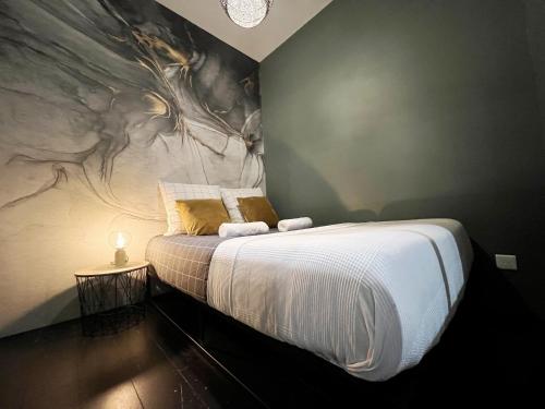 une chambre avec un lit avec un tableau sur le mur dans l'établissement BeauConcept, à Nantes