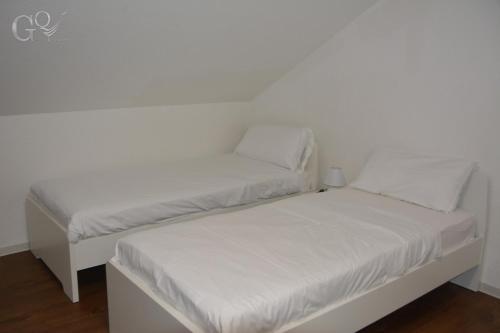 two twin beds in a room with white walls at GQ Deluxe Apartment in Saarbrücken