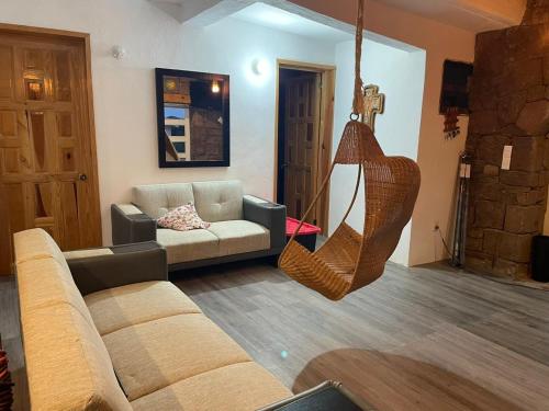 a living room with a couch and a hanging hammock at Cabañas Misión Amealco in Amealco