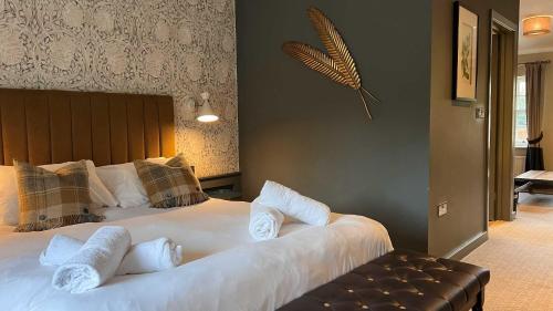 a bedroom with a large bed with white pillows at The Forresters Arms Kilburn in Kilburn