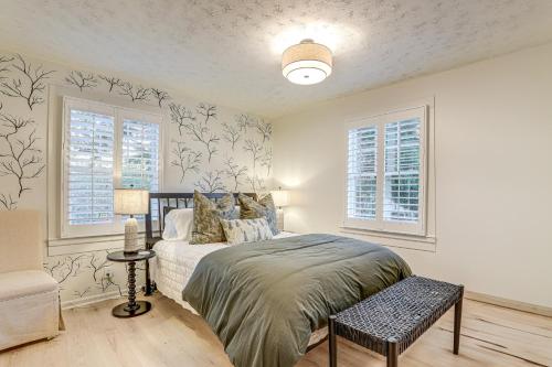a bedroom with a bed and two windows at Walk Downtown and Canton Street Roswell Retreat! in Roswell