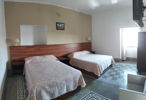 a hotel room with two beds and a window at Hotel Marmoy in Cholula