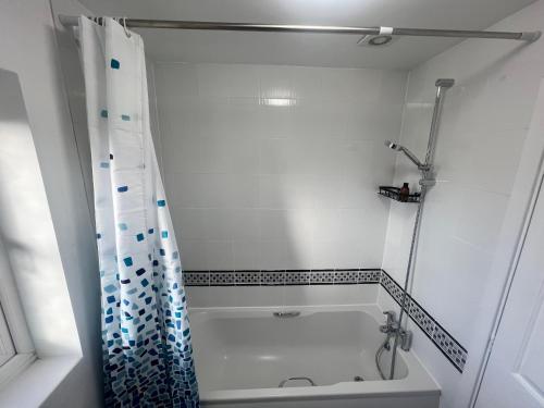 ein weißes Badezimmer mit Badewanne und Dusche in der Unterkunft New Manchester City Getaway House with 2 FREE Parking in Manchester