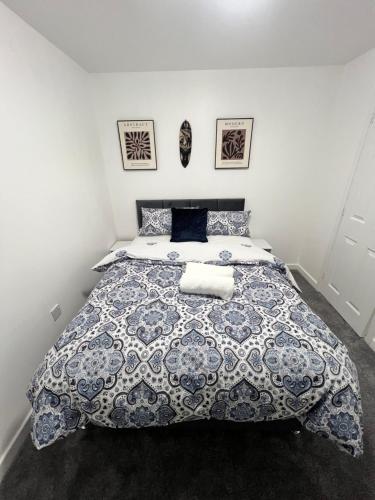 Schlafzimmer mit einem Bett mit einer blauen und weißen Bettdecke in der Unterkunft New Manchester City Getaway House with 2 FREE Parking in Manchester