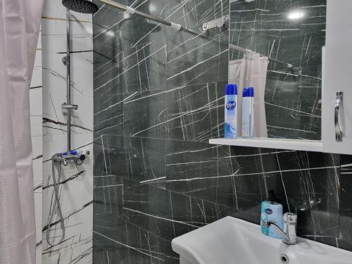 a bathroom with a sink and a shower at Sea apartment baTumi in Batumi