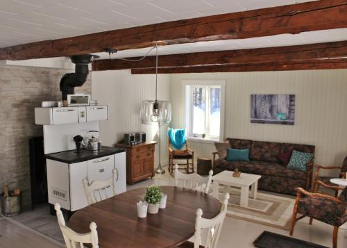 eine Küche und ein Wohnzimmer mit einem Tisch und einem Sofa in der Unterkunft Maison Du Vieux Chemin in Saint-Philémon