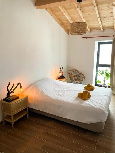 a bedroom with a bed with two yellow towels on it at Casa Barracuda in Faja Grande