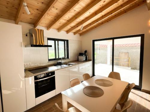 a kitchen with white cabinets and a table with chairs at Casa Barracuda in Faja Grande