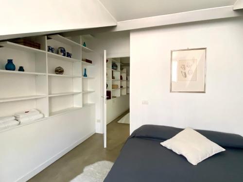- une chambre avec un lit bleu et des étagères blanches dans l'établissement Sant Ambrogio Courtyard Room in shared flat, à Milan