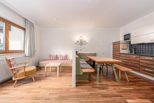 a kitchen and living room with a table and a dining room at Apartments Alpina in Mayrhofen