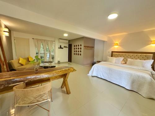 a bedroom with a bed and a table and a couch at Hotel La Casablanca Tayrona in Calabazo