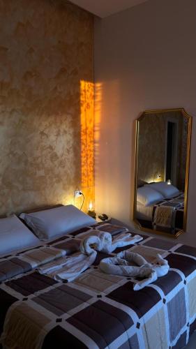 a bedroom with two beds and a mirror at Hotel Melydà in Pozzuoli