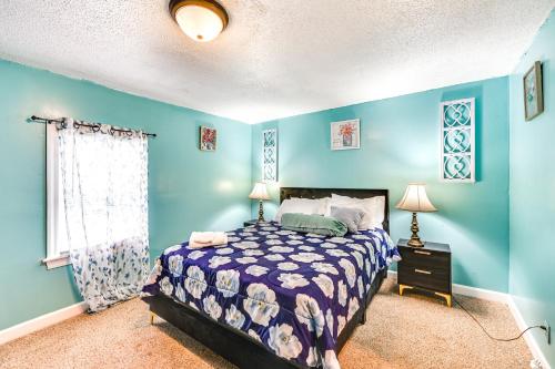 ein Schlafzimmer mit blauen Wänden, einem Bett und einem Fenster in der Unterkunft 1 Mi to Stadium Home with Porch in Greenville! in Greenville