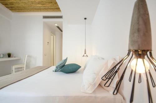 a bedroom with a bed with white sheets and pillows at Thomais Studios in Naxos Chora