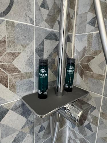 two bottles sitting on a shelf in a bathroom at Hotel Melydà in Pozzuoli